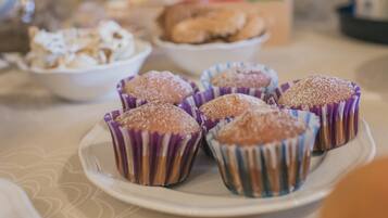 Ein Teller mit Muffins und Puderzucker auf einem Tisch.