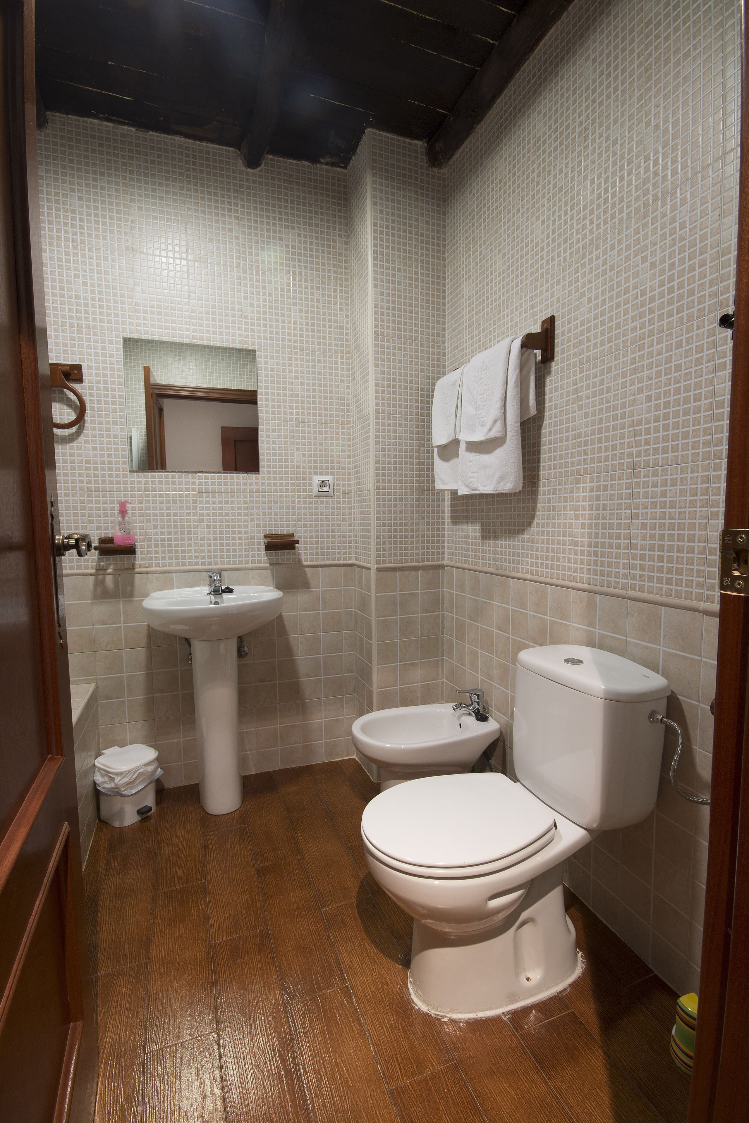 A bathroom with a sink, toilet, and bidet.