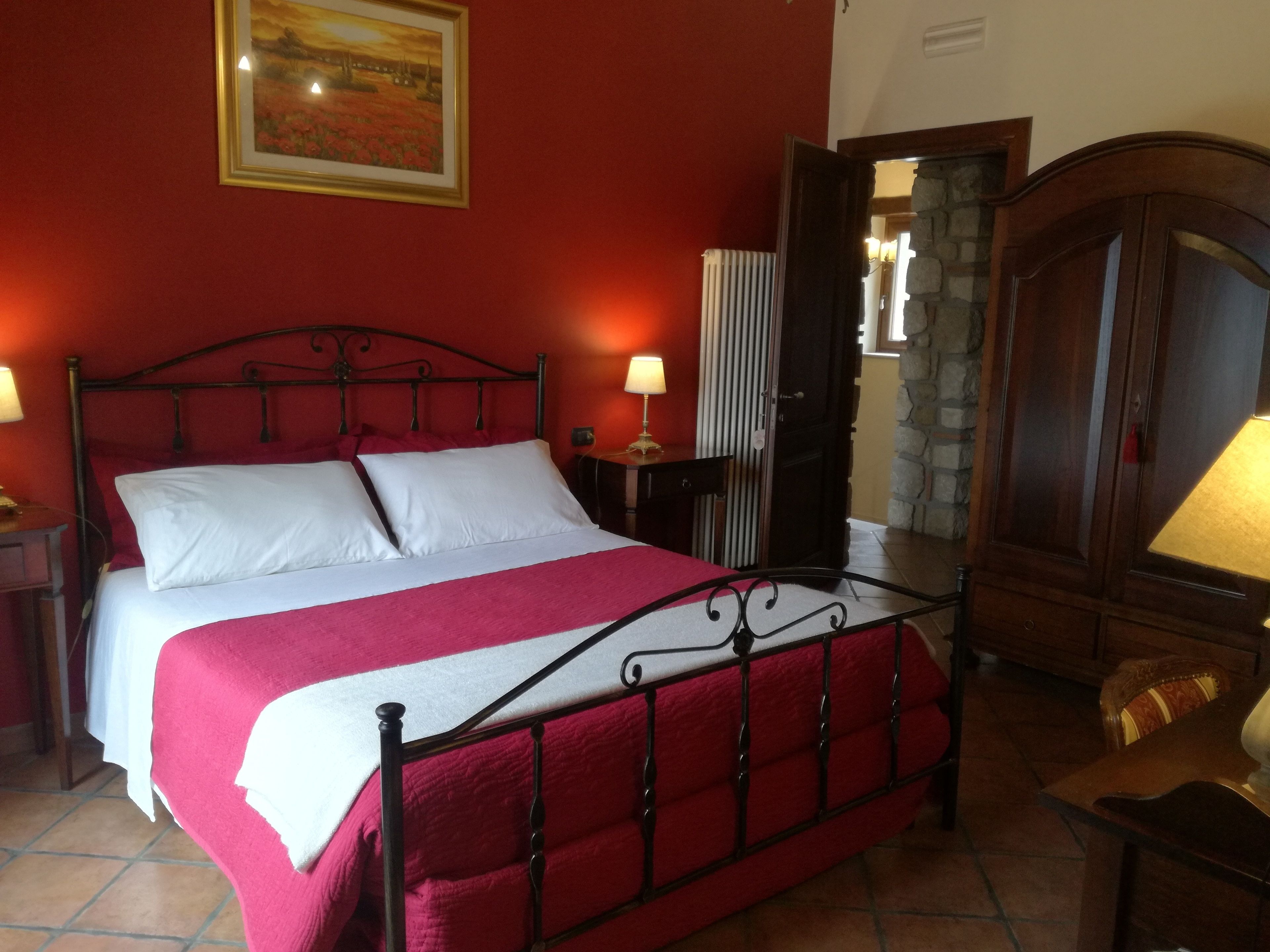 Une chambre à coucher avec un lit, une armoire en bois et un tableau accroché au mur.