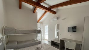Un dormitorio con literas, un escritorio, una silla, un televisor y un espejo.