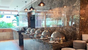 A buffet area with a marble counter, multiple serving stations, and overhead lighting.