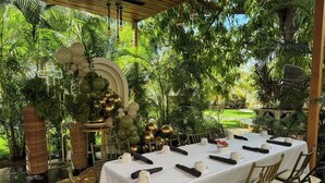 An outdoor dining area with a long table, chairs, and a decorative archway. - Hotel Palacio Maya (Mérida)