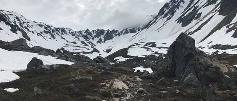Un paysage montagneux accidenté, parsemé de plaques de neige et de rochers.