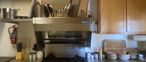 A kitchen with wooden cabinets, a stainless steel stove, and a range hood.
