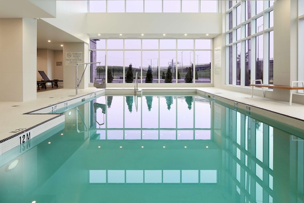 Una piscina techada, sillones reclinables de piscina