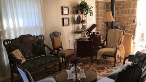 A traditional living room with a sofa, chairs, a table, and a fireplace.