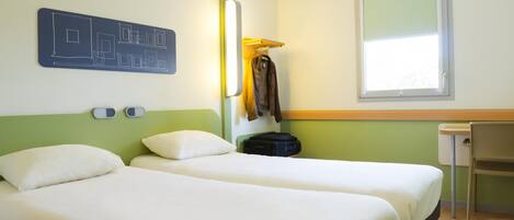 A hotel room with two beds, a desk, a chair, a coat rack, and a window.