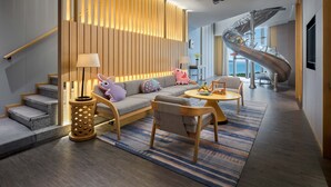 A modern living room with a sofa, a coffee table, and a unique spiral staircase.