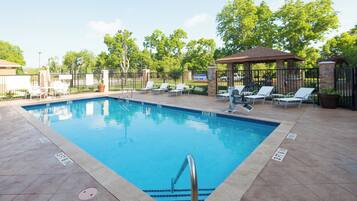 Una piscina al aire libre, sillones reclinables de piscina