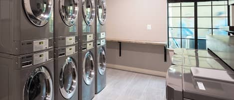 A laundry facility with multiple stacked washing machines and dryers.