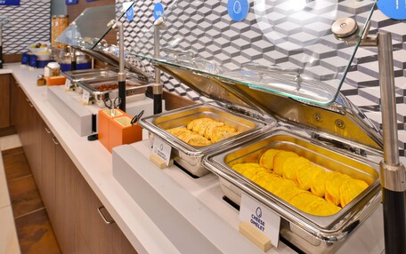 A buffet with labeled containers of omelets and other dishes.