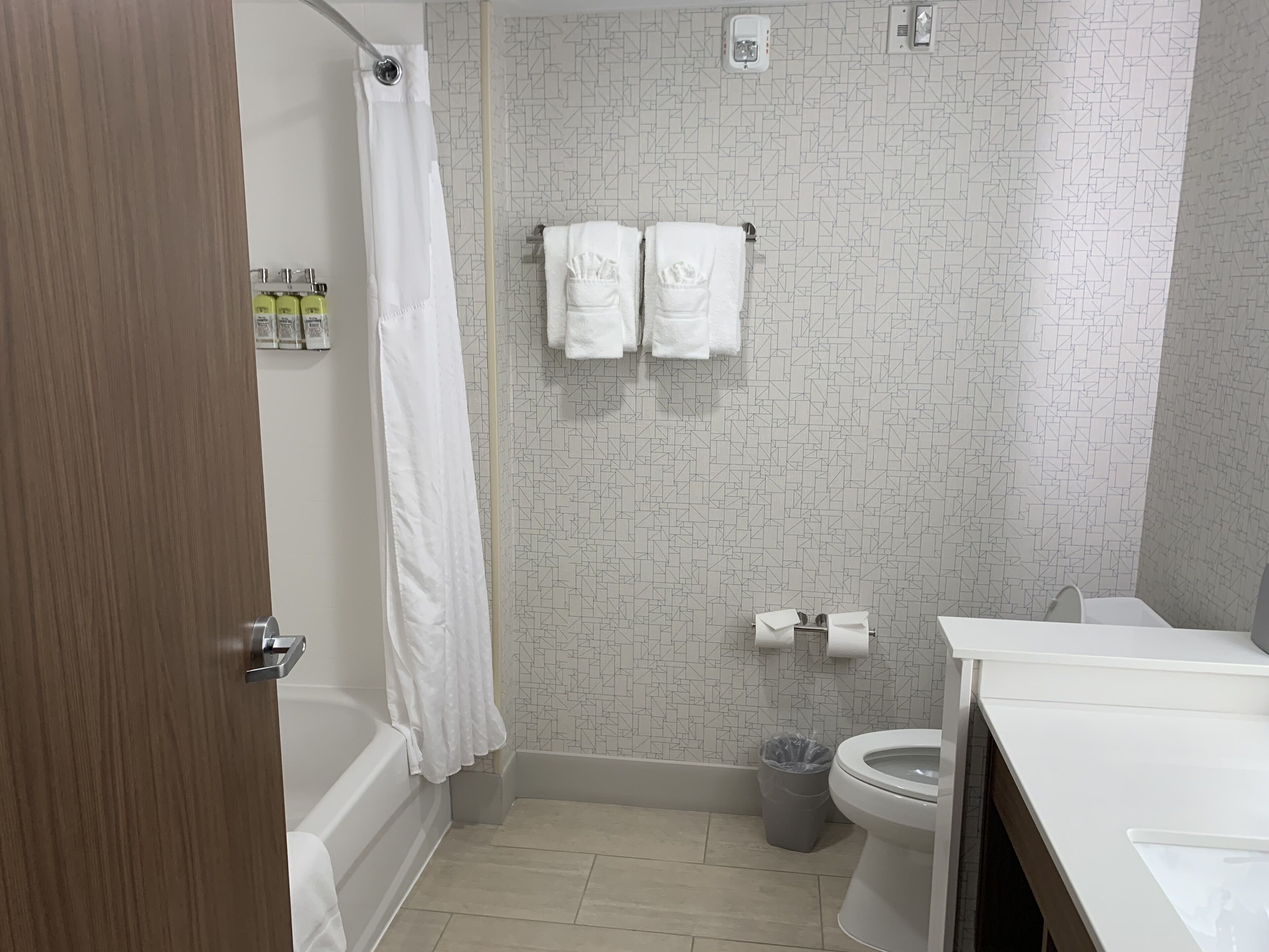 A bathroom with a shower, toilet, and sink.