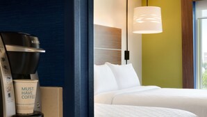Ein Hotelzimmer mit einer Kaffeemaschine, einem Bett und einem Fenster mit Blick.