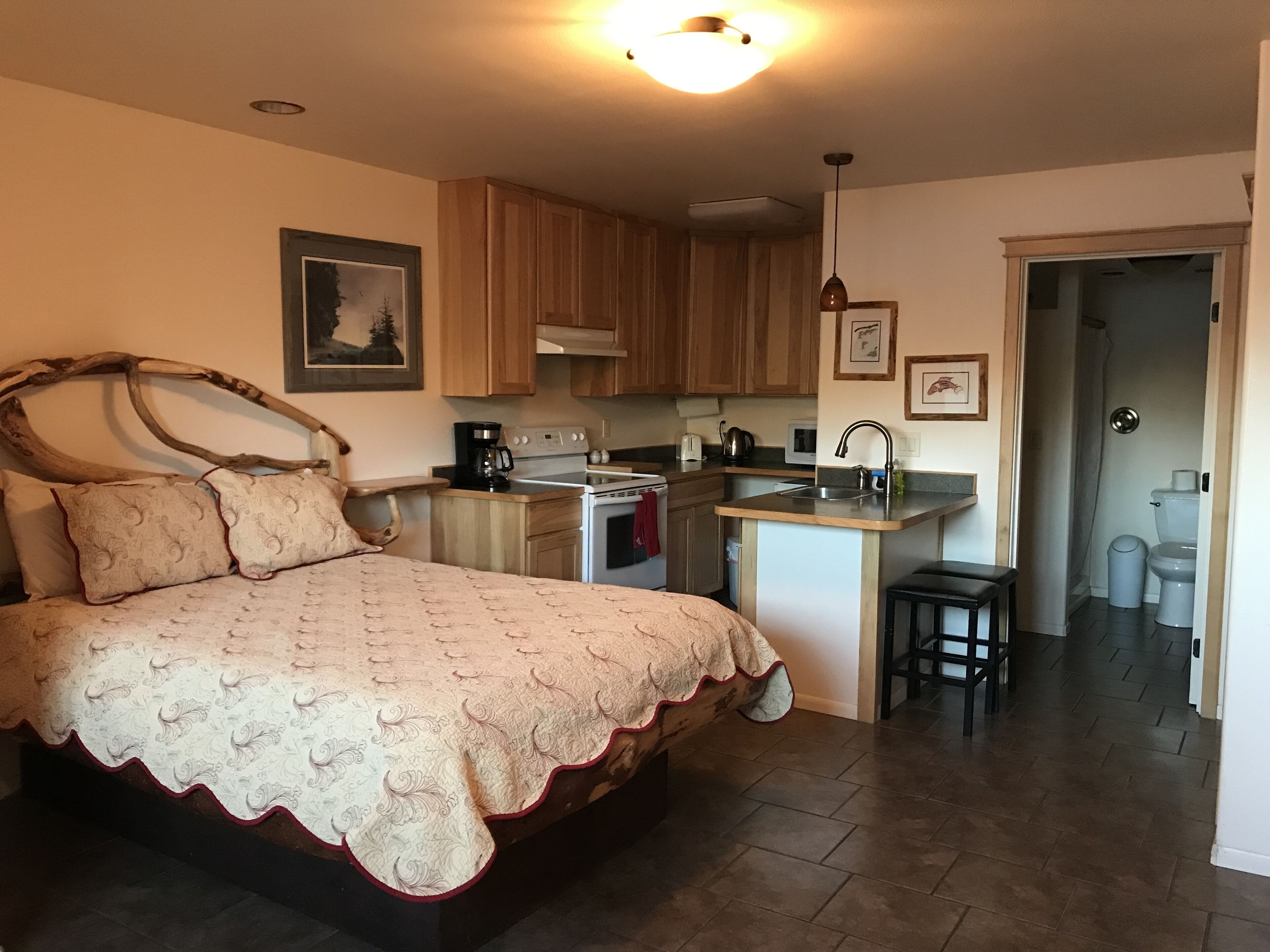 Ein Schlafzimmer mit einem großen Bett, einer Küchenzeile und einem Badezimmer.