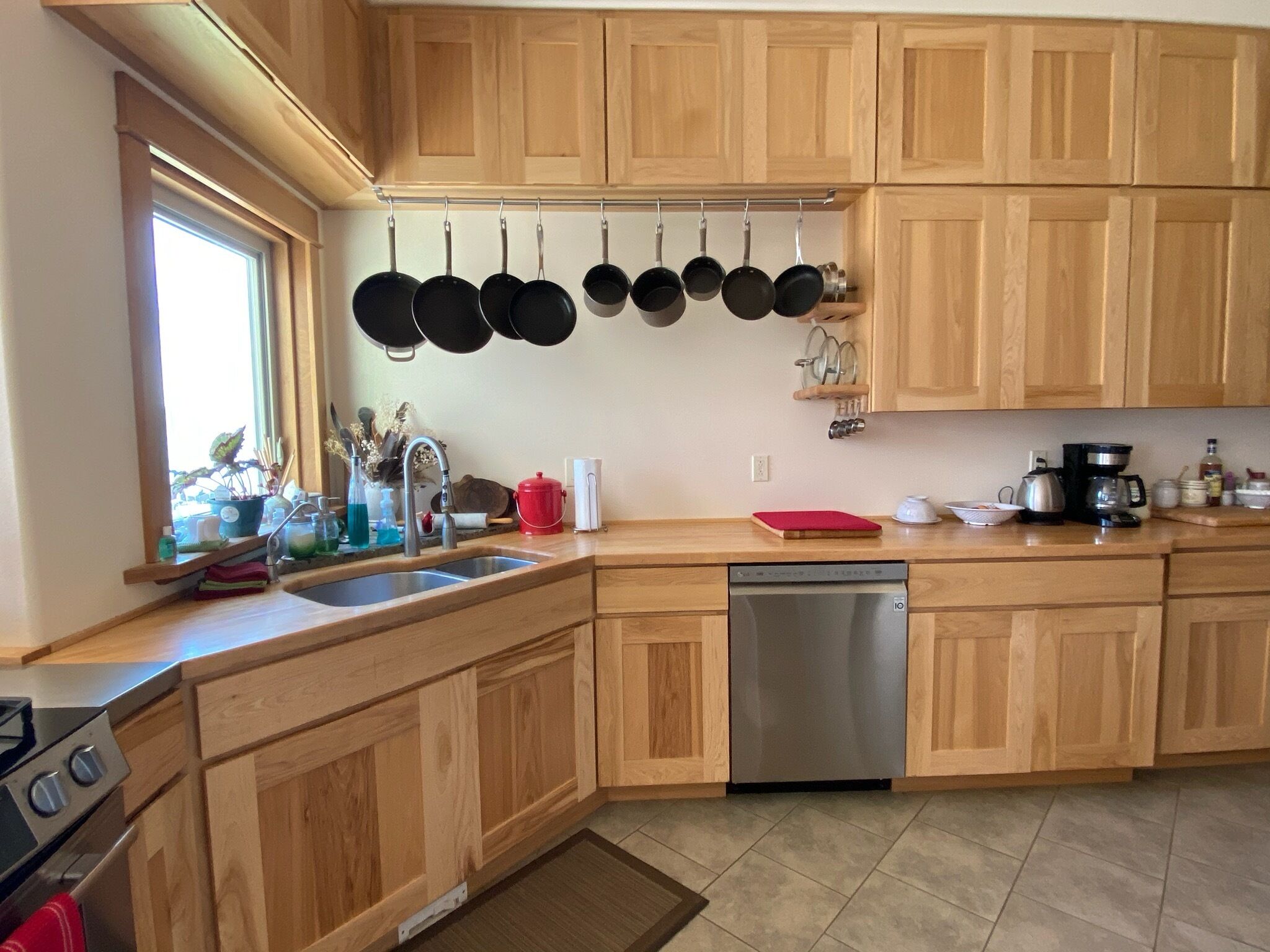 Une cuisine avec des meubles en bois, un lave-vaisselle en acier inoxydable et une fenêtre avec vue.