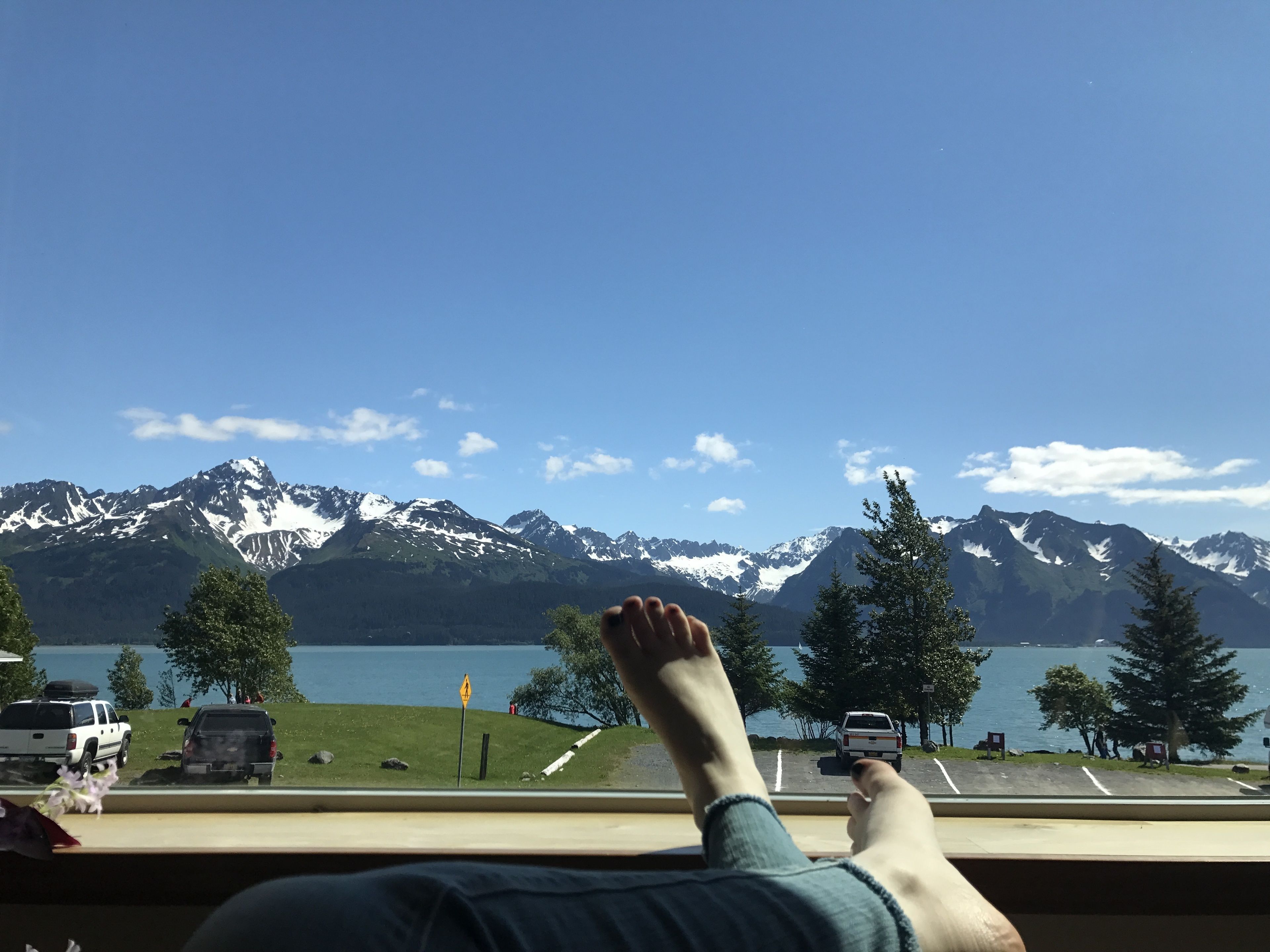 Une personne se détend, profitant de la vue sur un lac et des montagnes.
