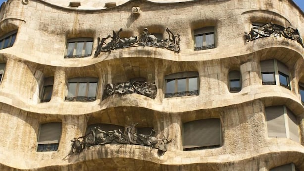 A building with a unique architectural design featuring multiple balconies and decorative sculptures.