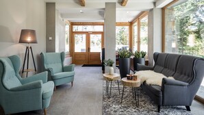 Un interior moderno con un sofá, dos sillones, una lámpara y una mesita de centro.