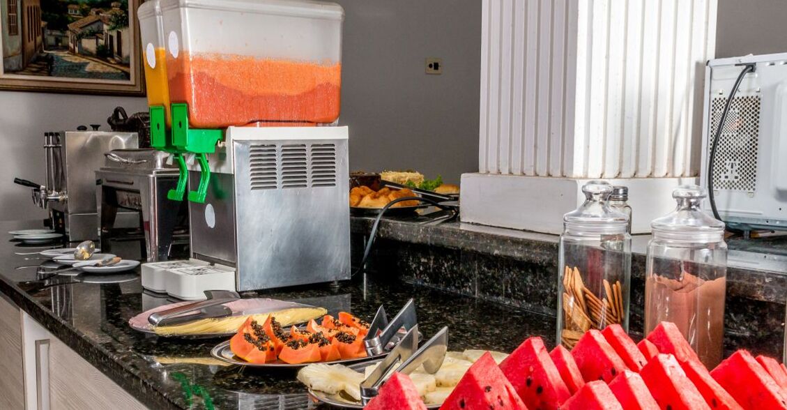 A buffet setup with various food items and a beverage dispenser.