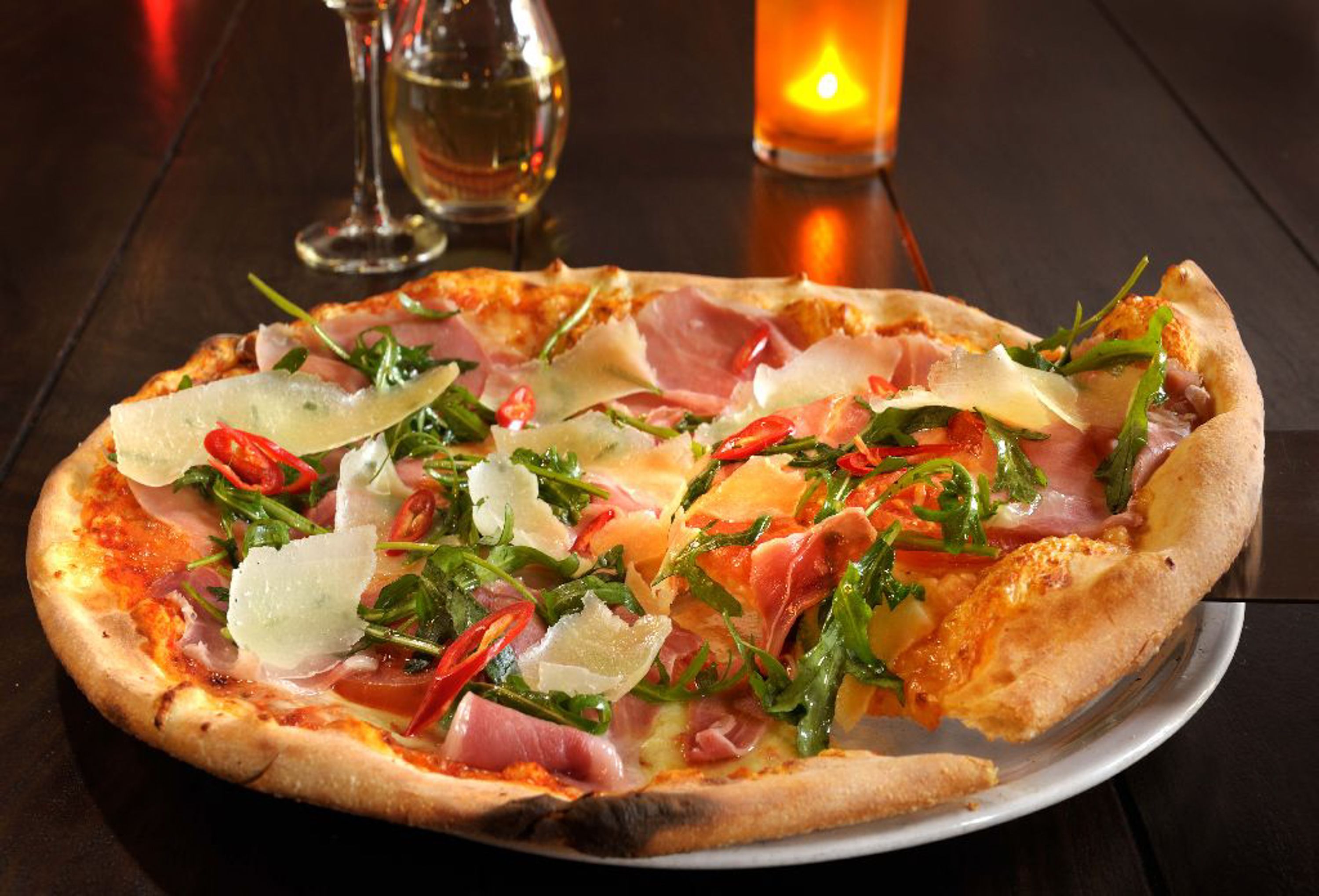 A pizza with various toppings on a white plate.
