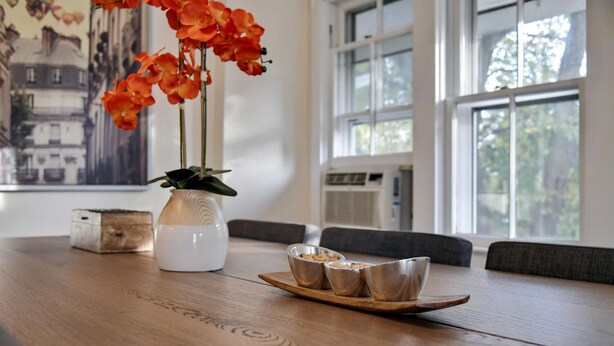 A wooden table with a white vase and three metal bowls on a tray, a small wooden box, and a painting on the wall. - Top-Floor Princeton Condo w/private balcony (Princeton)