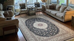 A spacious living room with a large window, a fireplace, and a cozy seating area. - Lake Muskoka in Muskoka Bay (Gravenhurst)