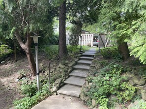 Un escalier en pierre menant au sommet d’une colline, entouré d’arbres et de verdure.