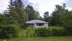A single-story house surrounded by dense greenery and trees. - Simcoe Georgina Family Cottage Winter-Summer Rent 1hr from Toronto (Willow Beach)