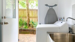 Une cuisine compacte équipée d’un lave-linge encastré, d’un évier et d’un étendoir.