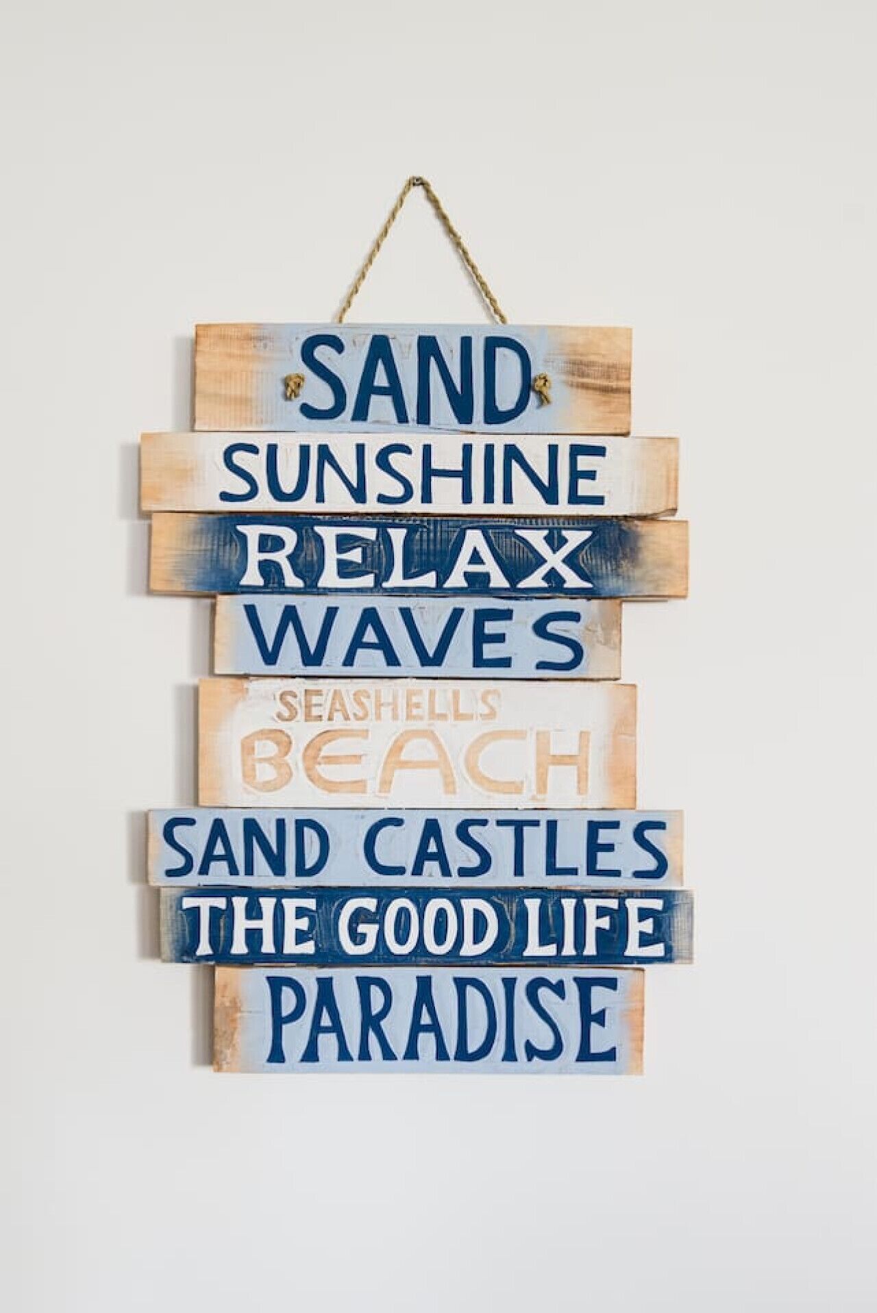 A vertical arrangement of wooden signs with text, each sign is of different sizes and colors, hanging from a string.