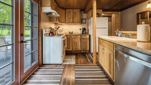 A compact kitchen with wooden cabinets, a built-in stove, and a dishwasher.