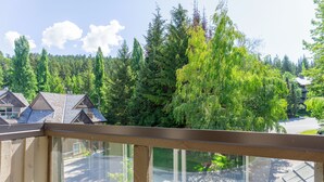 Ein Wohngebiet mit Häusern, einem großen Baum und blauem Himmel.