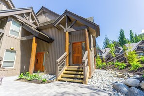 A wooden lodge with a central entrance, stone steps, and a surrounding garden. - Painted Cliff 16 Ski-in, Ski-out Luxury with serene mountain views, sleeps 8 (Whistler)