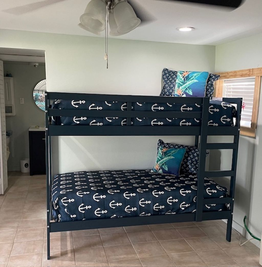 A bunk bed with a nautical theme, featuring anchor patterns on the bedding.