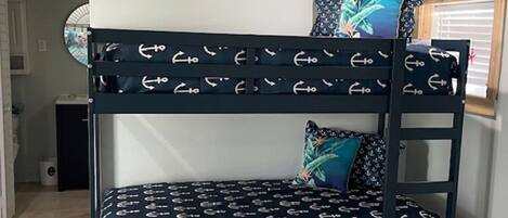 A bunk bed with a nautical theme, featuring anchor patterns on the bedding.
