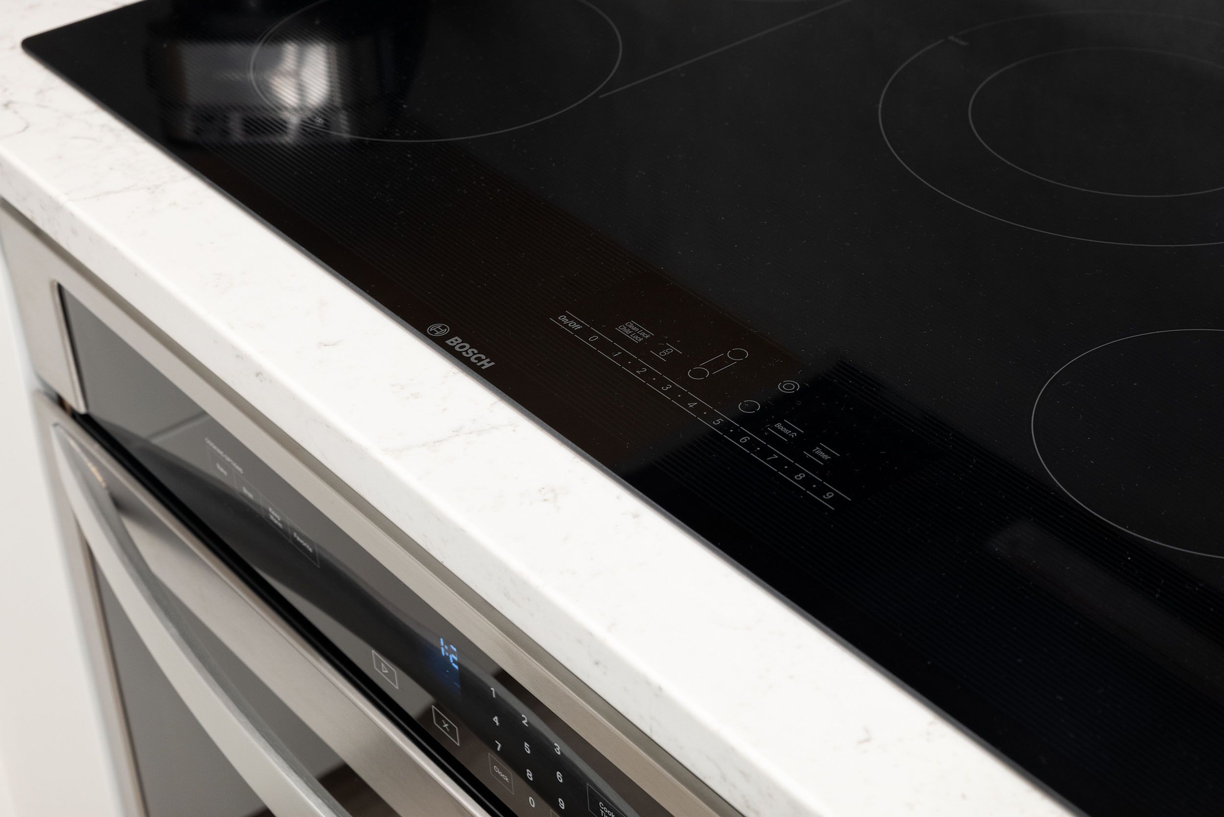 Una cocina con horno empotrado y placa de inducción negra.