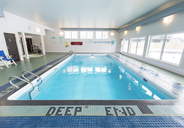 A swimming pool with a 'DEEP END' sign, clear water, and a tiled floor. - Gimli Beach Condos # 2 - Gimli's best location! (Gimli)