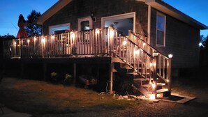 Een huis met een houten terras, een trap en een garage.