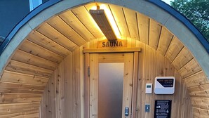 Un sauna avec des murs en bois, un banc, un panneau de commande et un panneau indicateur.