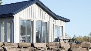 Un bâtiment moderne doté de grandes fenêtres et d’une fondation en pierre.