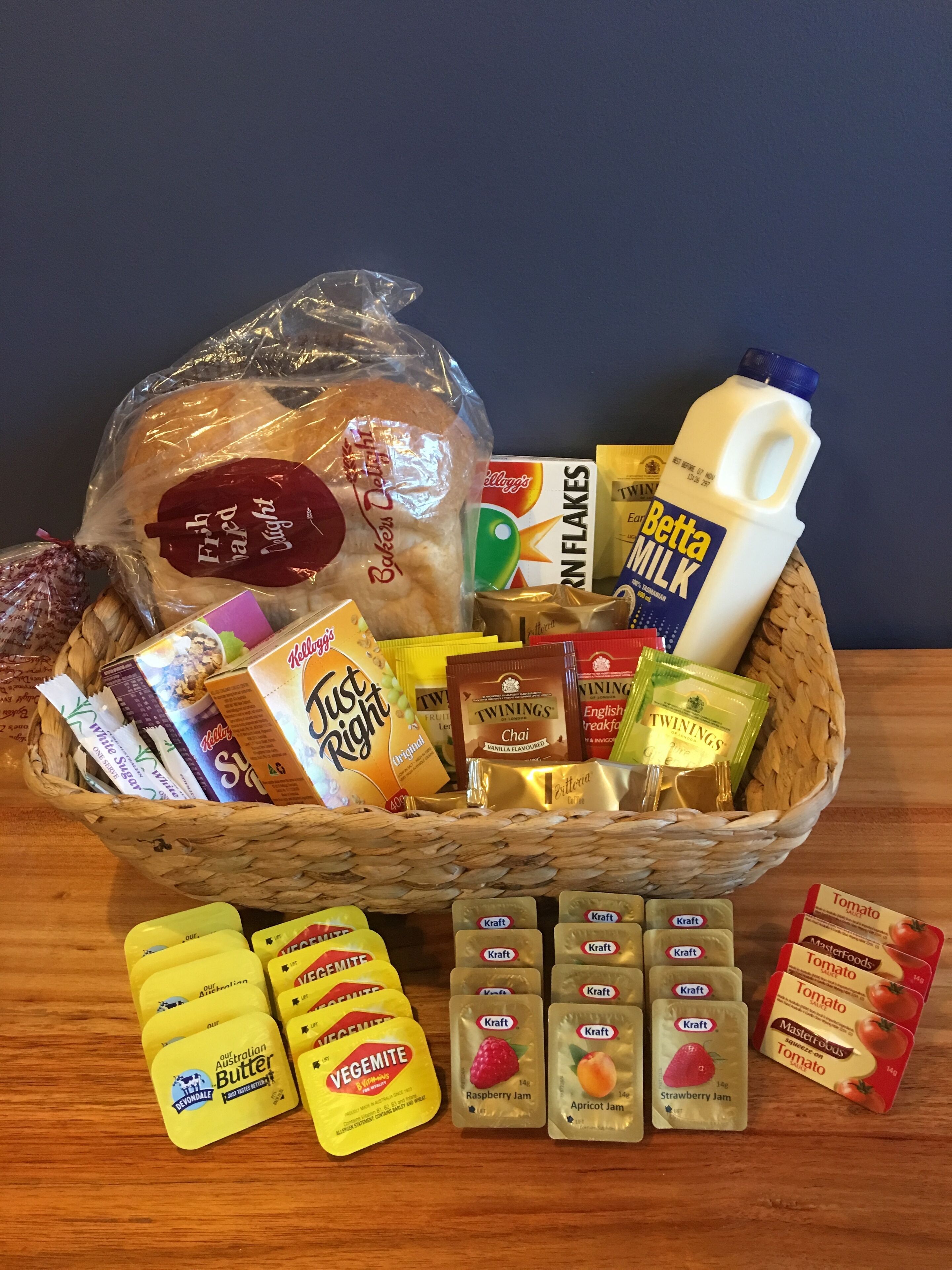 A basket filled with various food items including bread, milk, and condiments.