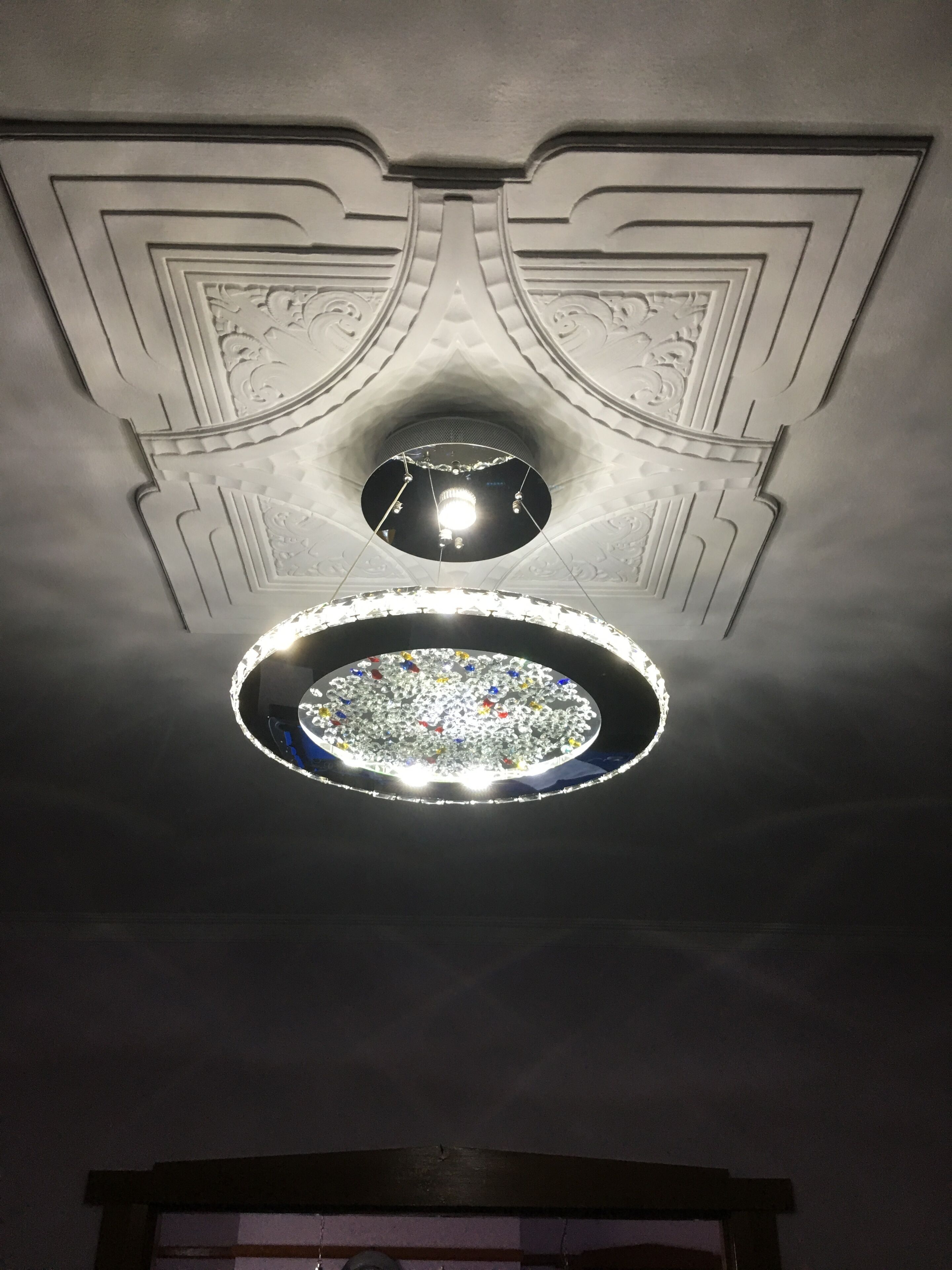 A ceiling with a circular skylight and a central light fixture.