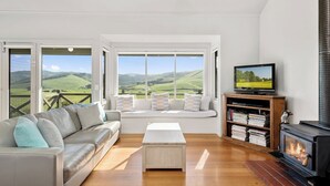Una sala de estar con un sofá, una mesa de centro, un televisor, una estantería y una chimenea.