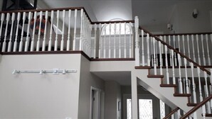 A multi-level staircase with white balusters and wooden handrails.