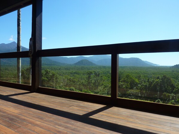 A wooden deck with a view of a dense forest and mountains. - Daintree Holiday Homes - La Vista - Ocean Views with Private Pool & Jet Spa (Daintree)