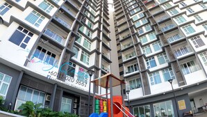 Un edificio residencial de varios pisos con balcones y ventanas grandes.