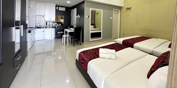 A hotel room with two beds, a small kitchenette, a dining area, and a bathroom. - Cahaya Qaira - D'Perdana Kota Bharu (Kota Bharu)