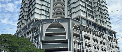 Un edificio de varios pisos con una entrada destacada y señalización que indica 'PERDANA Sri Cemerlang'.