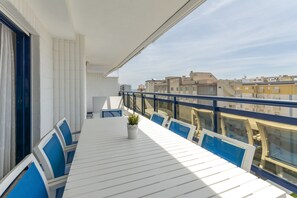Enjoy the city view from this balcony with a table and chairs.