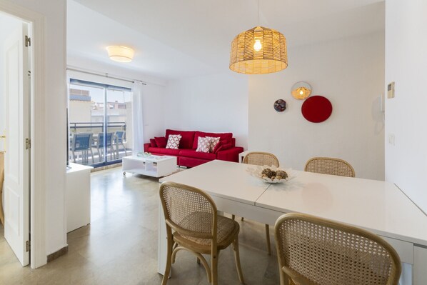 Relax in this stylish living space with a dining table, comfortable sofa, and large window offering a view of the outside.